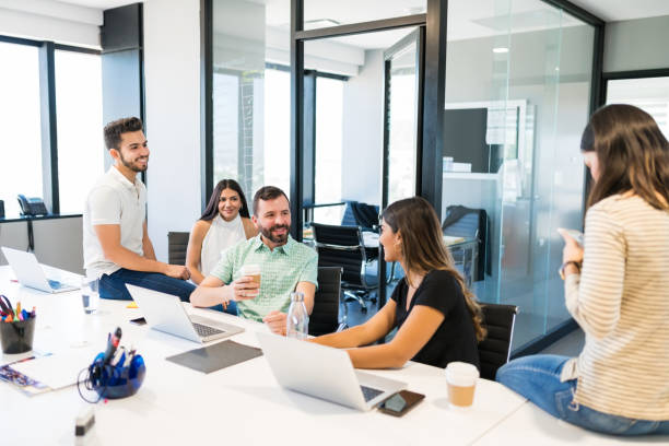 istock Coworkers Discussing Over Coffee In Office 1184211034