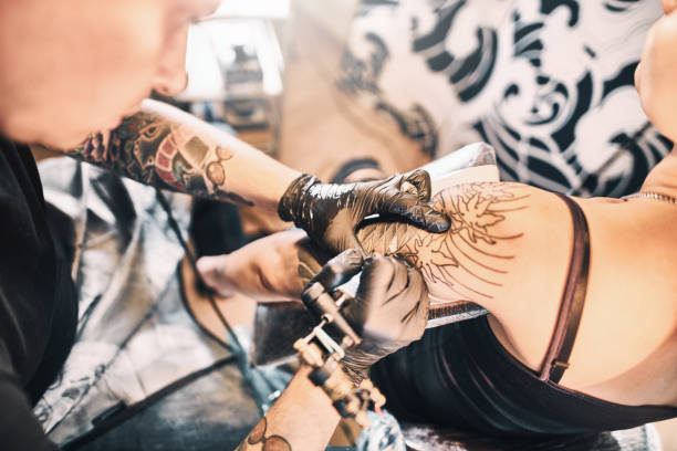 istock Tattoo Artist making a tattoo on a customer's shoulder 1184211531