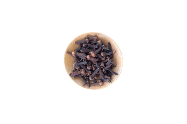 Cloves in wooden bowl isolated on white background.