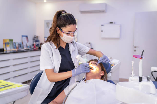 frau bekommt zahnbehandlung in einer zahnarztpraxis - dentist dental hygiene dental drill dentist office stock-fotos und bilder
