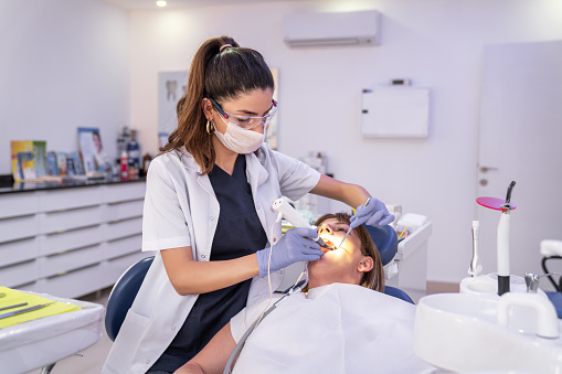 Woman is getting dental treatment in a dental clinic.
