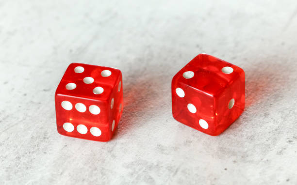 istock Two translucent red craps dices on white board showing Natural or Seven Out (number 5 and 2) 1184219399