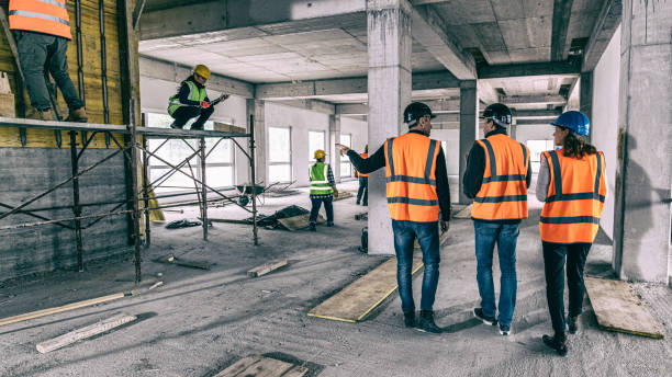 istock Construction foreman guiding investor and architect through a construction site 1184220900