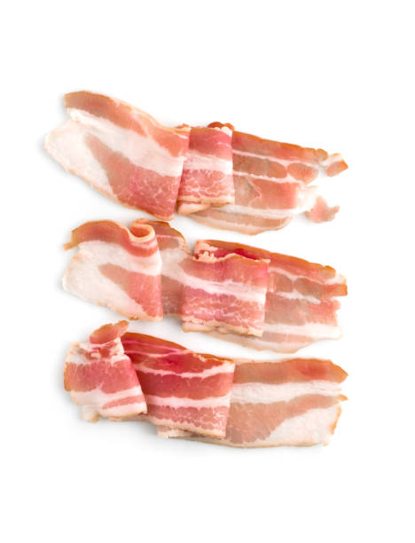 A slice of bacon on a white background. Three raw bacon close up on a white background. Top view. A slice of bacon on a white background. Three raw bacon close up on a white background. Top view. twisted bacon stock pictures, royalty-free photos & images