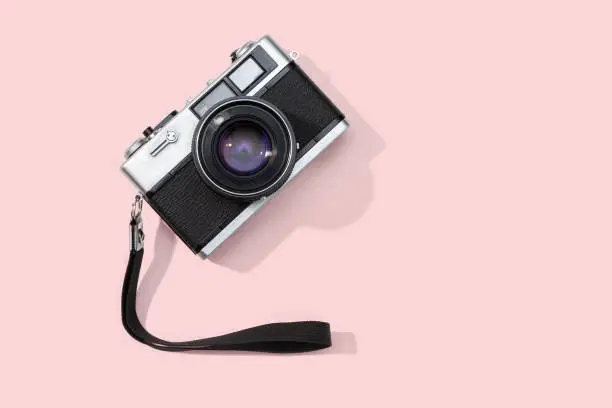 Photo of Flat lay film camera isolated on pink background