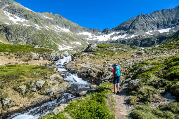 istock Schladming - A gilr hiking up a path along the mountain stream 1184222227