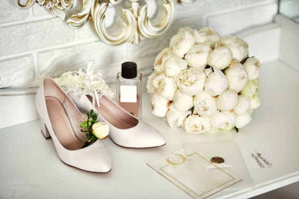 istock bridal accessories such as shoes, bouquet , ring and perfume lie on a table 1184222689