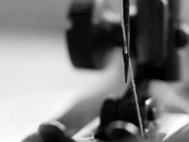 istock sewing machine and item of clothing macro 1184225642