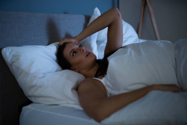 istock Sad Woman Lying On Bed 1184225689