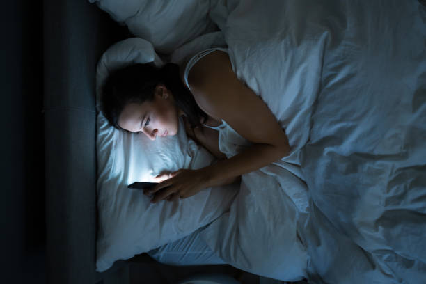 istock Woman In Bed With Mobile Phone 1184225693