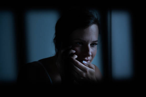 istock Prisoner Woman Using Cellphone in Jail 1184225697