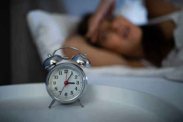 istock Sleepless Woman Looking At Clock 1184225705