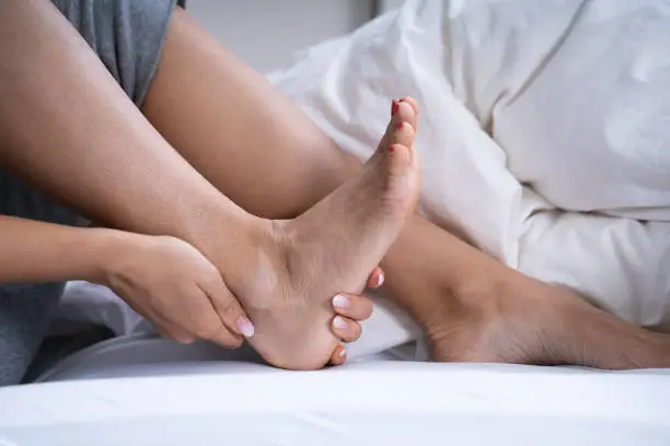 Woman Feeling Achilles Heel Pain In Bed