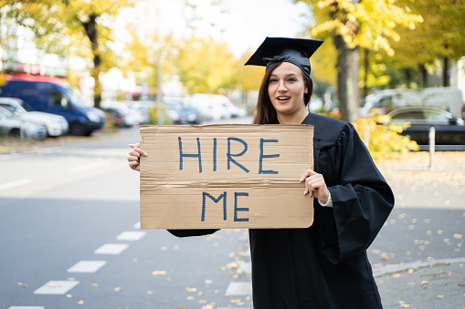 Graduate Student Standing With Hire Me Placard On Street