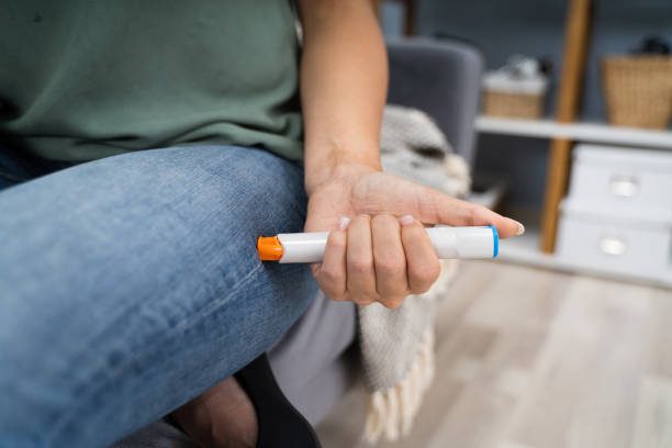 woman injecting epinephrine using auto-injector syringe - adrenaline imagens e fotografias de stock