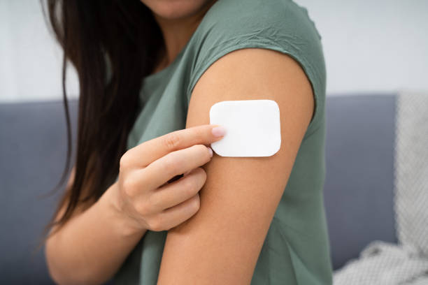 istock Woman Applying Patch On Her Arm 1184225812