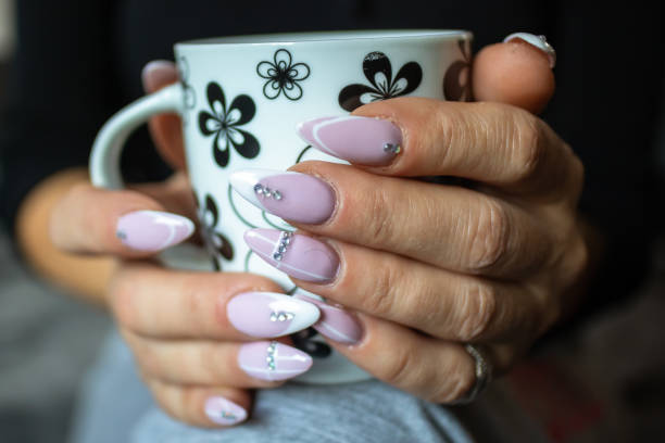 istock Women's hands with manicured nails holds cup of coffee 1184226429