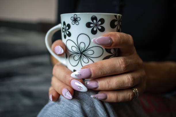 istock Women's hands with manicured nails holds cup of coffee 1184227053