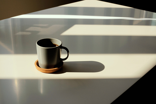Coffee cup on table photo taken in natural sunlight