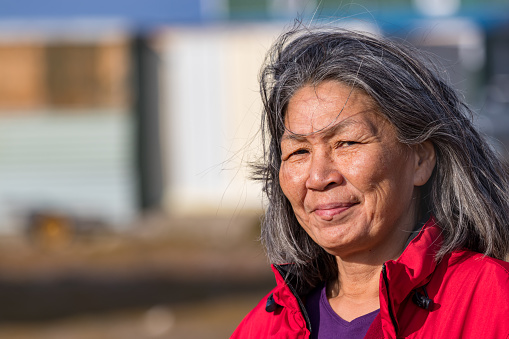Clyde River, Baffin Island, Canada - August 20th, 2019: Portrait of a local inuit woman outdoors in Clyde River, Nunavut, Canada.