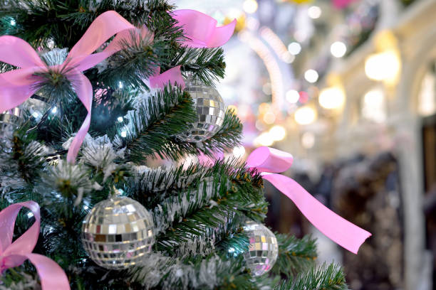 istock Silver christmas balls and pink bows on Christmas tree 1184233225