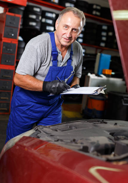 istock Auto mechanic recording list of works 1184233872