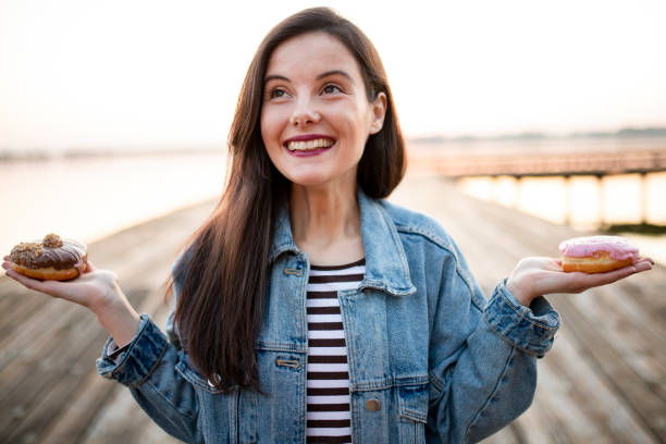istock Woman thinking about donut 1184234134