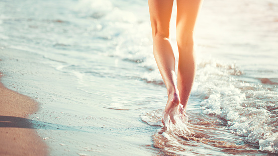 Family feet relaxing and sunbathing in sand on the beach concept for vacation and summer holiday