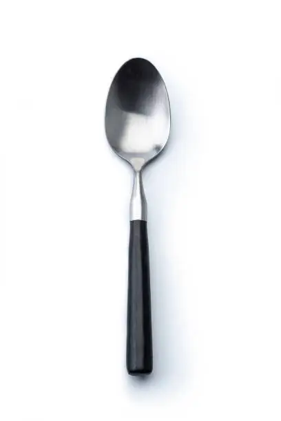Single spoon agains a white background, high angle view