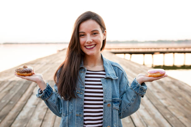 istock Woman holding donuts and posing 1184235434