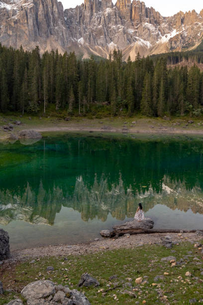 istock Woman standing and looking at Lago di Carezza in Dolomites 1184238162