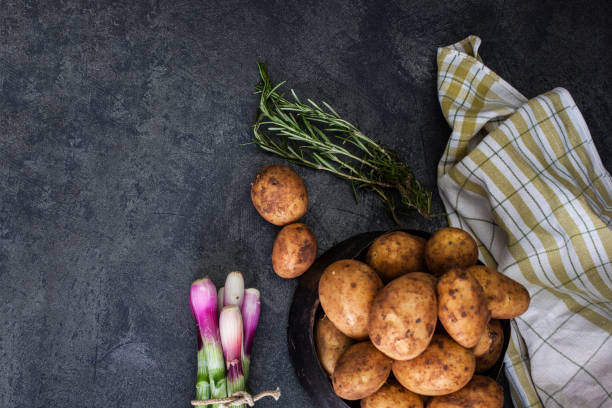 istock Spring onions and potatoes on dark background 1184239614