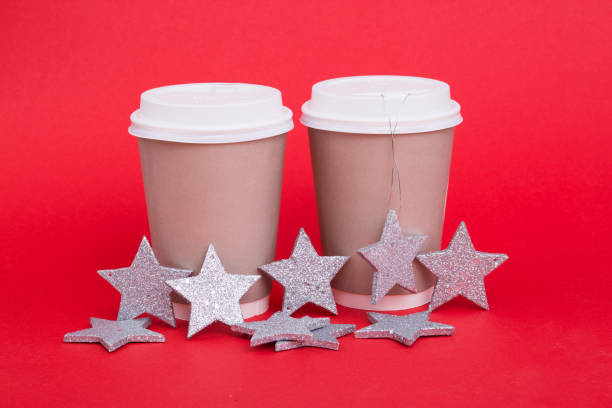 istock Paper cups for coffee on a red background with New Year stars. 1184239821