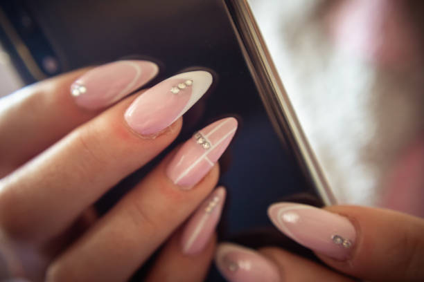 istock Women's hands with manicured nails holds smartphone 1184243342