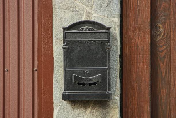 istock one black metal mailbox hanging on a gray fence 1184244656