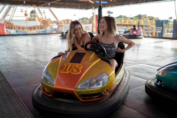 istock Happy girlfriends driving a bumper car and smiling 1184246115