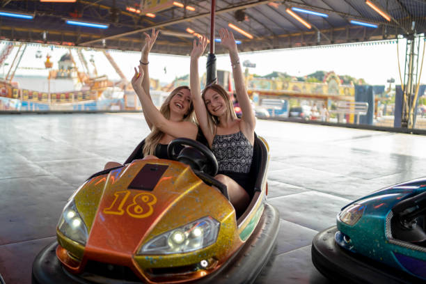 istock Happy girlfriends driving a bumper car and smiling 1184246222