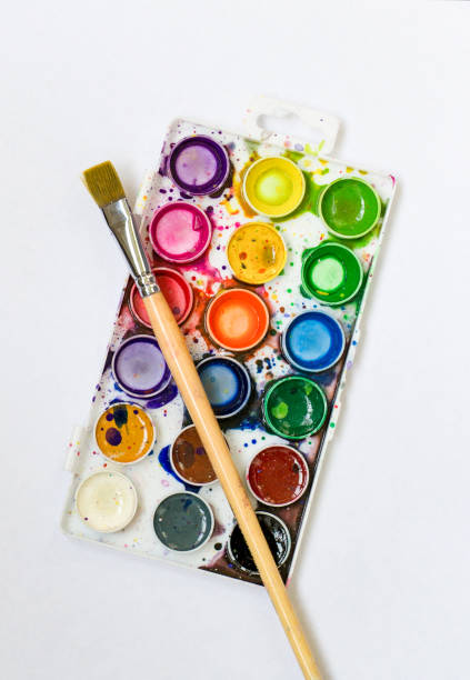 istock Watercolor palette and paintbrush on blank white sheet and blue-space background 1184247609