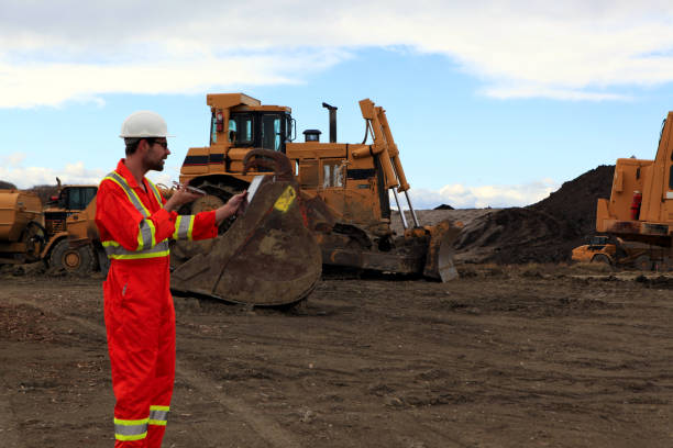 istock Male Construction worker looking at tablet while talking on the phone at work site 1184248686