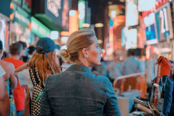 blonde girl walking in at times square rear shoot of a blonde girl, solo travelling at new york city, times square midtown manhattan tourism new york city usa stock pictures, royalty-free photos & images