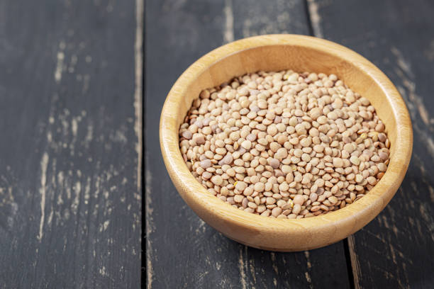 istock Bowl with green lentils on a white wooden background. 1184250523