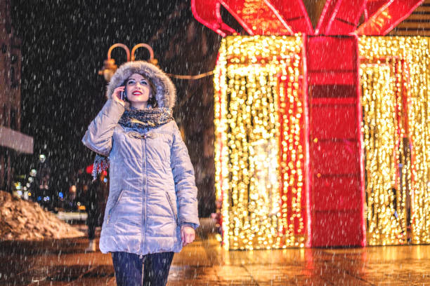 istock Woman using mobile phone on the winter night 1184251251