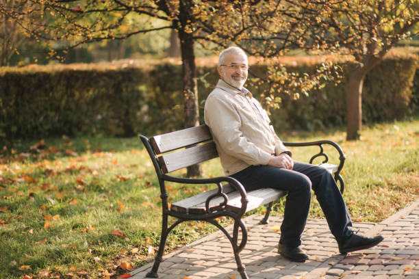 istock Old gray-haired man rest on the bench in autumn park 1184252934