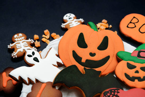 istock The hand-made eatable gingerbread Halloween pumpkin, ghosts, bat and sceletons on black background 1184253162