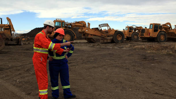 istock Male and Female Construction workers looking at tablet and pointing at work site 1184254628