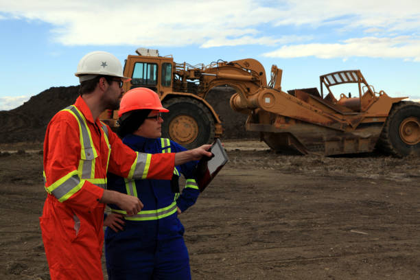 istock Male and Female Construction workers having a discussion with a tablet at work site 1184255585