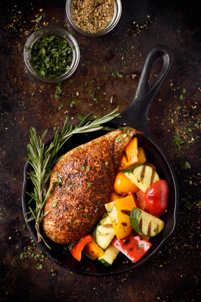 Roast chicken breast and grilled vegetables Roast chicken breast with grilled vegetables in a cast iron skillet main course stock pictures, royalty-free photos & images