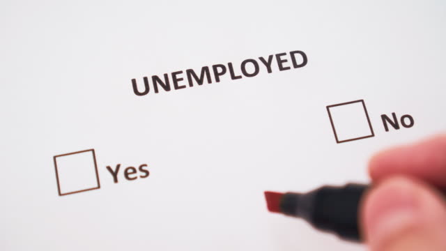 A hand puts a check mark next to YES on white paper under the word UNEMPLOYED in the checklist