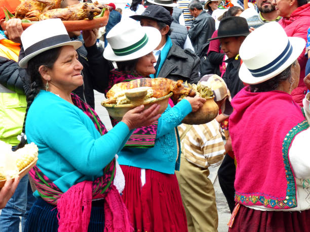 Village woman carries a dish with roasted guinea pig Cuenca, Ecuador - June 21, 2019: Village women of Azuay province in traditional dress carry bowls with typical food ginea pig at the parade on Inti Raymi celebration in Cuenca, Ecuador. inti raymi stock pictures, royalty-free photos & images