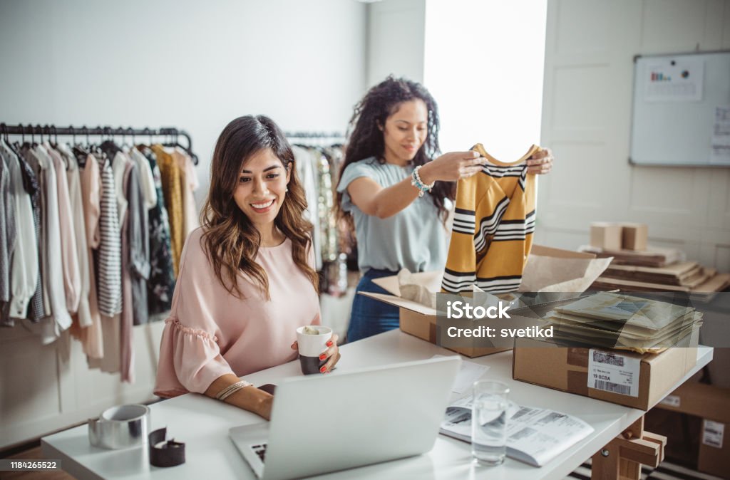 Small business owners Working women at their store. They wearing casual clothing, accepting new orders online and packing merchandise for customer E-commerce Stock Photo